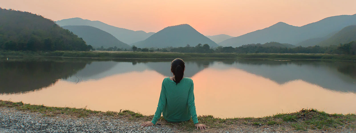 woman staring out at lake and mountains