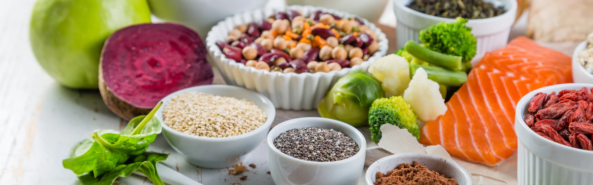 table with foods such as salmon, broccoli, and beans